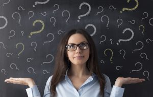 Business woman with question mark on a blackboard